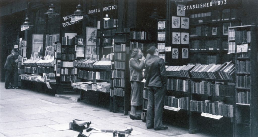 a person and person looking at books on a shelf